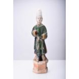 A Chinese Sancai green-glazed standing figure, Tang Dynasty