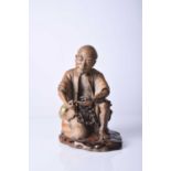 A Chinese Shiwan figure of a seated man, Qing Dynasty