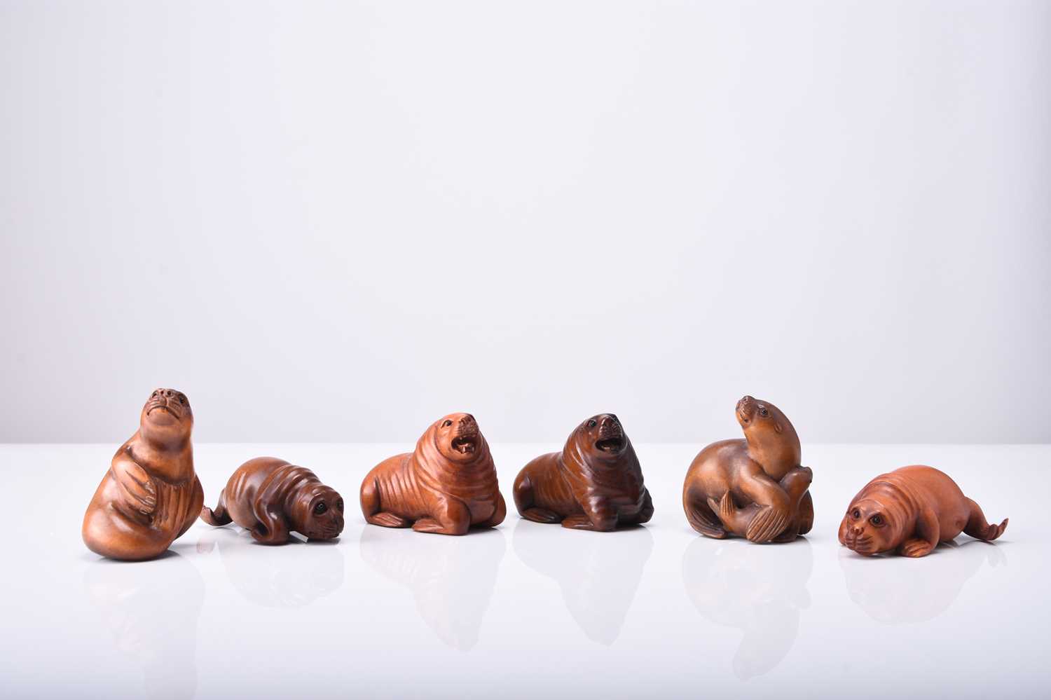 A group of six Japanese wood netsuke of seals and sea lions, 20th century