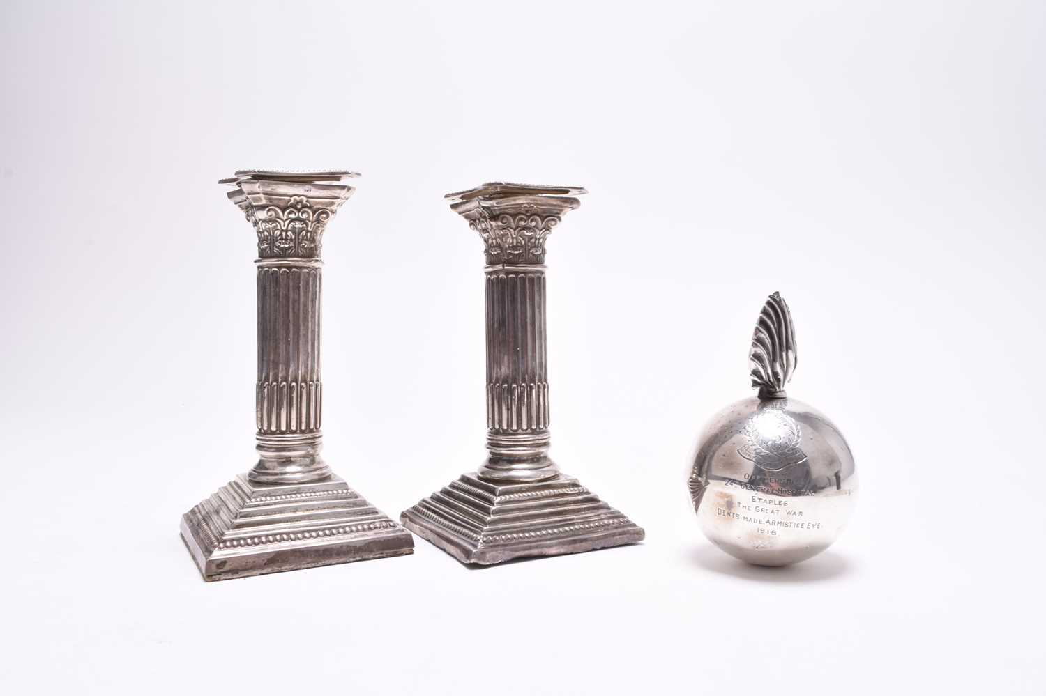 A novelty silver table lighter in the form of a bomb and two candlesticks