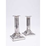 A pair of Edwardian short silver candlesticks