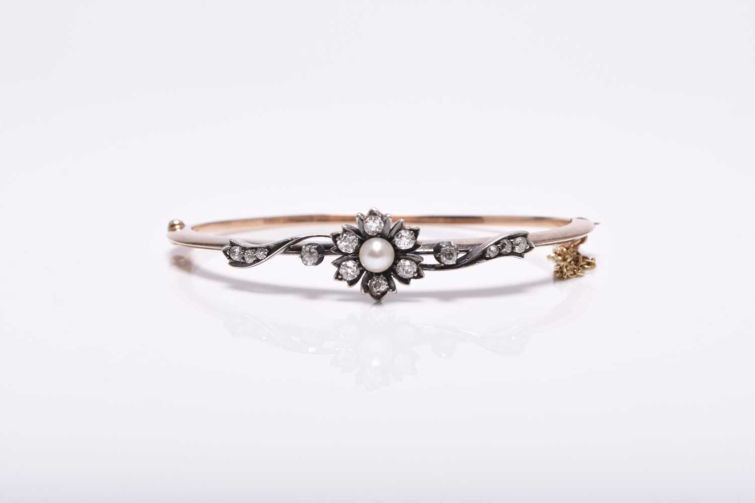 A late 19th / early 20th century diamond and cultured pearl hinged bangle