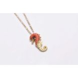 A coral and sapphire set seahorse pendant on chain
