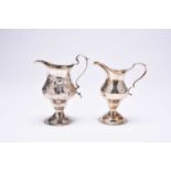 Two silver pedestal cream jugs