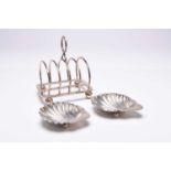 A silver four division toast rack and two silver shell dishes