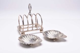 A silver four division toast rack and two silver shell dishes
