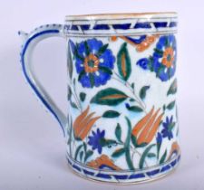 A TURKISH IZNIK MUG painted with flowers. 16 cm high.