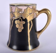 AN ART NOUVEAU LIMOGES PORCELAIN TANKARD painted with grape vines. 14 cm high.