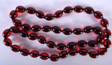 A CHERRY AMBER TYPE RED BEAD NECKLACE. 85 grams. 82 cm long.
