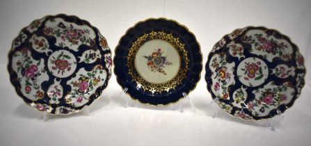 18th century Worcester pair of plates painted with flowers in gilt panels on a blue scale ground and