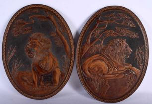 AN UNUSUAL PAIR OF ART DECO LEATHER EMBOSSED PANELS depicting lions in landscapes. 30 cm x 22 cm.
