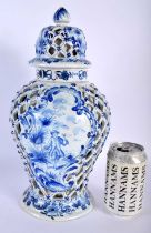 A LARGE ANTIQUE DELFT BLUE AND WHITE RETICULATED VASE AND COVER painted with figures within