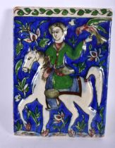 A MIDDLE EASTERN PERSIAN RELIEF PAINTED POTTERY HORSE AND RIDER TILE. 22 cm x 15 cm.