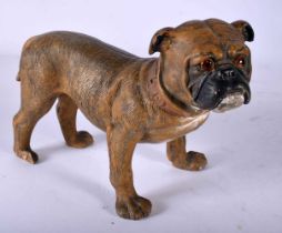 A SMALL 19TH CENTURY AUSTRIAN COLD PAINTED TERRACOTTA DOG modelled with glass eyes. 18 cm x 15 cm.