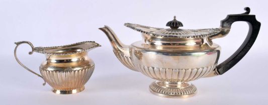 AN ANTIQUE SILVER TEAPOT AND CREAM JUG. 1022 grams. Birmingham 1912 & 1915. Largest 27 cm x 15