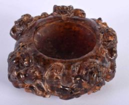 A CHINESE QING DYNASTY CARVED AMBER SCHOLARS BRUSH WASHER overlaid with clambering buddhistic lions.