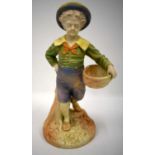 Royal Worcester figure of a boy with a basket and a broad brimmed hat painted in shot enamels