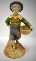 Royal Worcester figure of a boy with a basket and a broad brimmed hat painted in shot enamels
