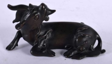 A 17TH/18TH CENTURY CHINESE BRONZE FIGURE OF A STYLISED BEAST Ming/Qing, modelled as a recumbent