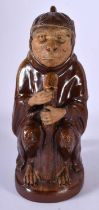 A 19TH CENTURY AUSTRIAN TERRACOTTA TREACLE GLAZED TEAPOT AND COVER formed as a monkey holding a