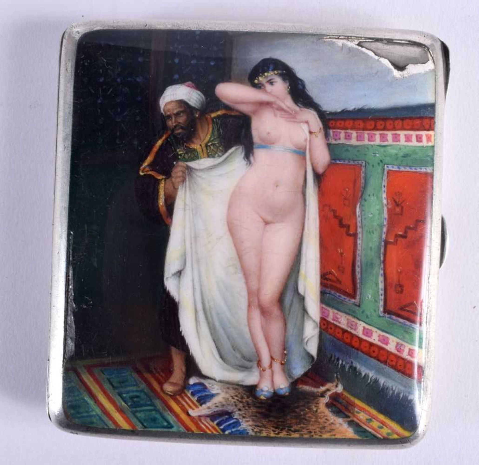 AN ART DECO SILVER AND ENAMEL CIGARETTE CASE painted with a Middle Eastern male revealing a nude