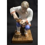 A LATE 19TH CENTURY RUSSIA ST PETERSBURG PORCELAIN FIGURE OF A COBBLER modelled repairing a shoe. 14