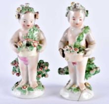 A PAIR OF 18TH CENTURY DERBY PORCELAIN FIGURES modelled encrusted with flowers. 10.5 cm high.