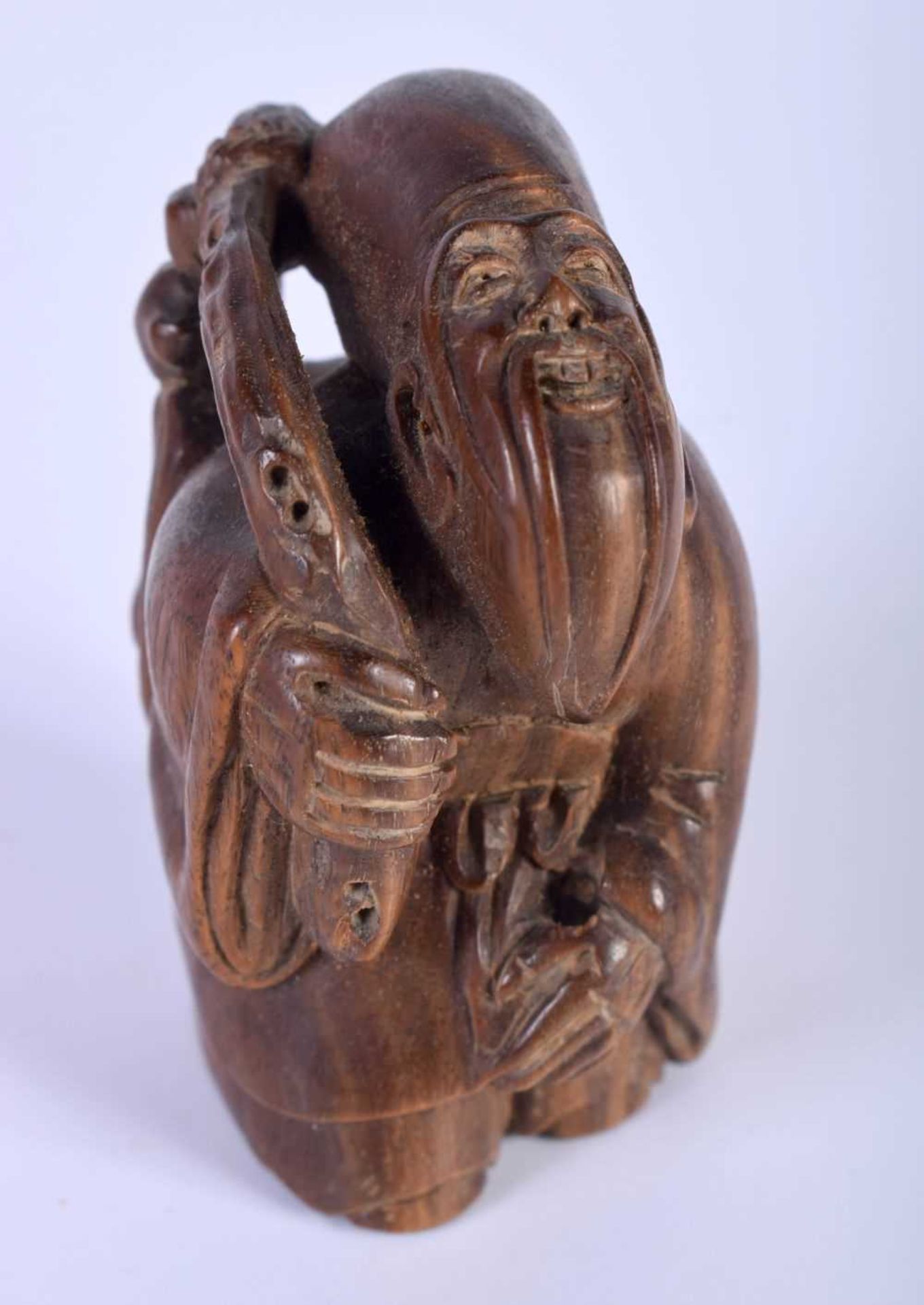 A Carved Hardwood Netsuke of a Male. 5.4cm x 3.2cm x 3.8cm. Weight 47g