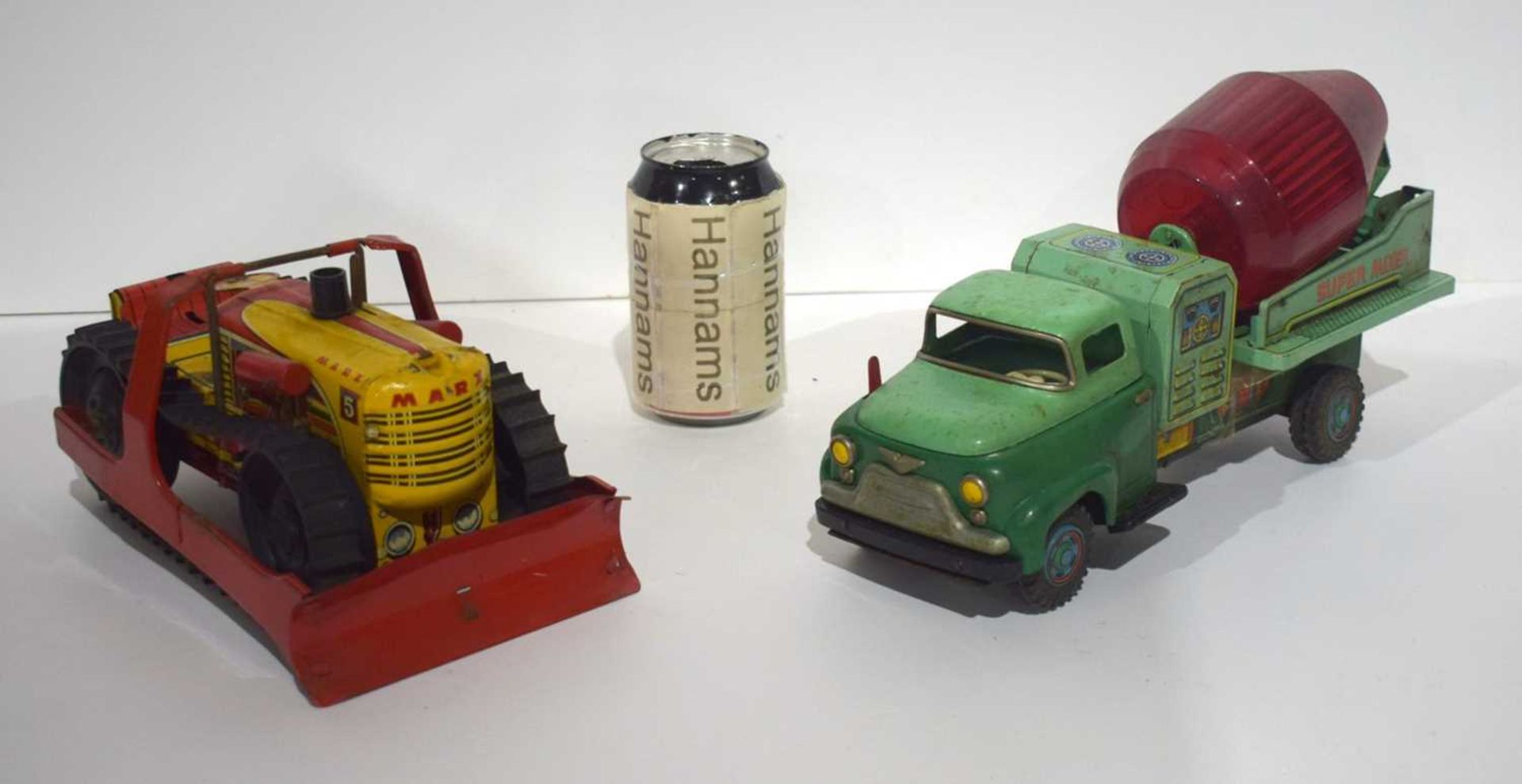 A 1960's battery operated Tin Super Mixer toy together with a Marx Caterpillar Earth Mover largest