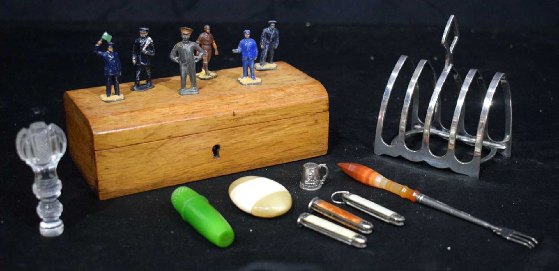 A miscellaneous collection Plate toast rack, miniature pen knives, lead soldiers, wooden box 17