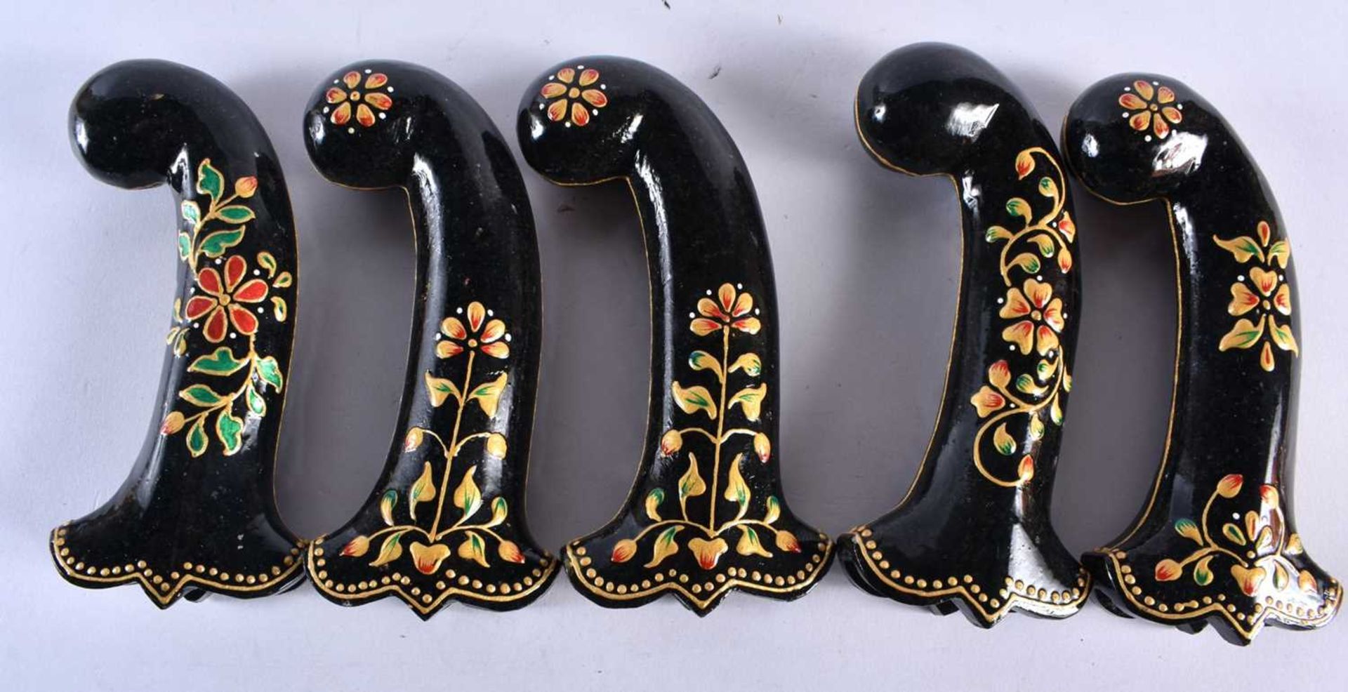 A SET OF FIVE MIDDLE EASTERN QAJAR LACQUER HARDSTONE DAGGER HANDLES overlaid with foliage and vines.