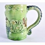 A RARE ANTIQUE GREEN GLAZED WHIELDON TYPE MAJOLICA MUG decorated in relief with figures. 14 cm x