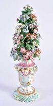 Bow vase of flowers with face mask handles painted in sea green and pink. 20cm high