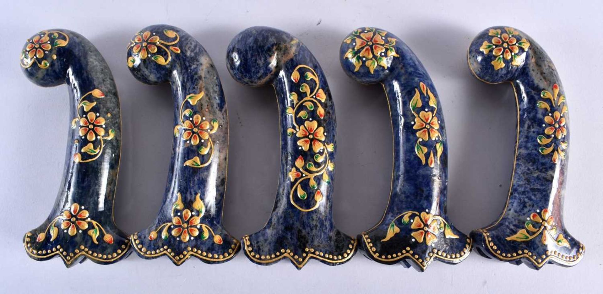 A SET OF FIVE MIDDLE EASTERN QAJAR LACQUER HARDSTONE DAGGER HANDLES overlaid with foliage and vines.