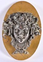 A 19TH CENTURY FRENCH GRAND TOUR SILVERED BRONZE WALL PLAQUE depicting a Romanesque mask head. 18 cm