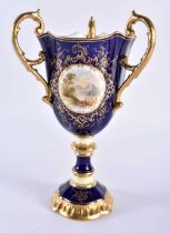 Late 19th early 20th century Coalport three handled loving cup painted with a Loch scene on a cobalt