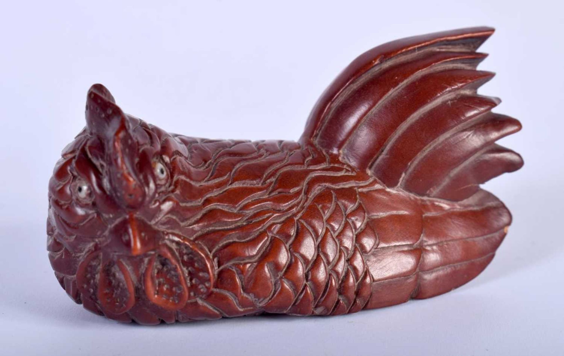 A Carved Hardwood Netsuke of a Chicken. 2.9cm x 6.2cm x 3.1cm. Weight 29g