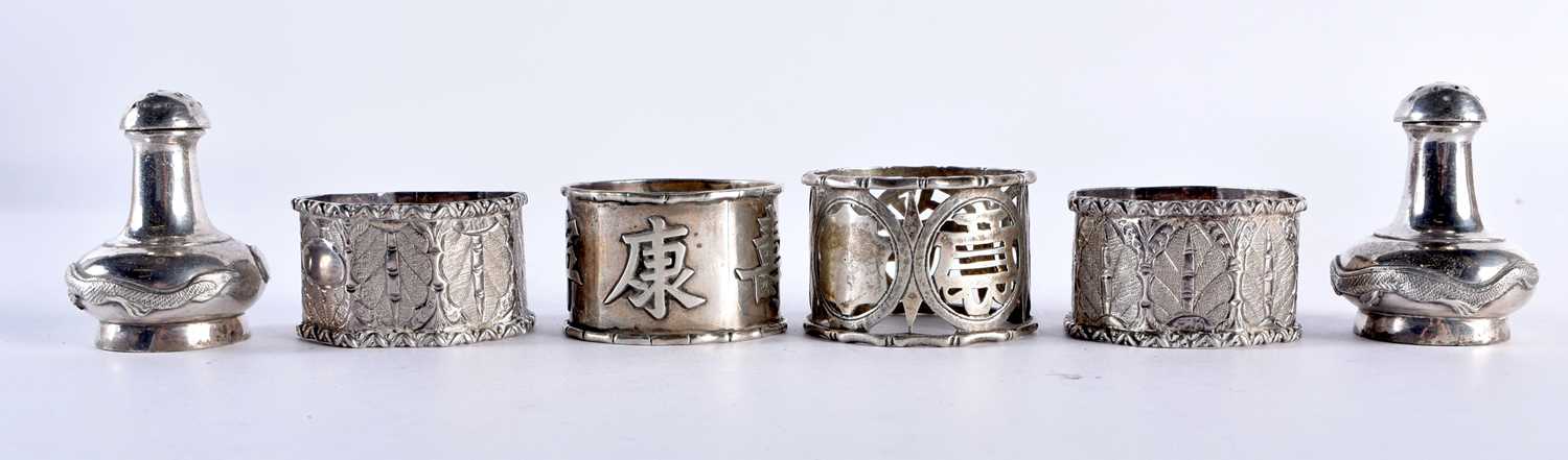 FOUR ASIAN SILVER NAPKIN RINGS and a pair of Chinese silver condiments. 174 grams. Largest 5 cm x