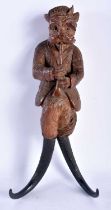 A 19TH CENTURY BAVARIAN BLACK FOREST CARVED WOOD COAT HOOK formed as a dog playing a pipe. 30 cm x