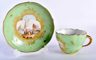A 19TH CENTURY MEISSEN PORCELAIN TEA CUP AND SAUCER painted with figures within landscapes.