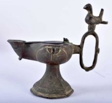 A 16TH/17TH CENTURY PERSIAN BRONZE OIL BURNER formed with an oval handle mounted with a bird, the
