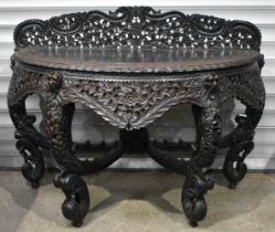 A LARGE 19TH CENTURY ANGLO INDIAN BURMESE CARVED WOOD CONSOLE TABLE decorated all over with foliage,