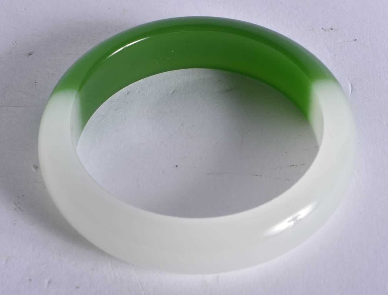 A CHINESE TWO TONE JADE BANGLE 20th Century. 59.4 grams. 6 cm wide. - Image 2 of 3