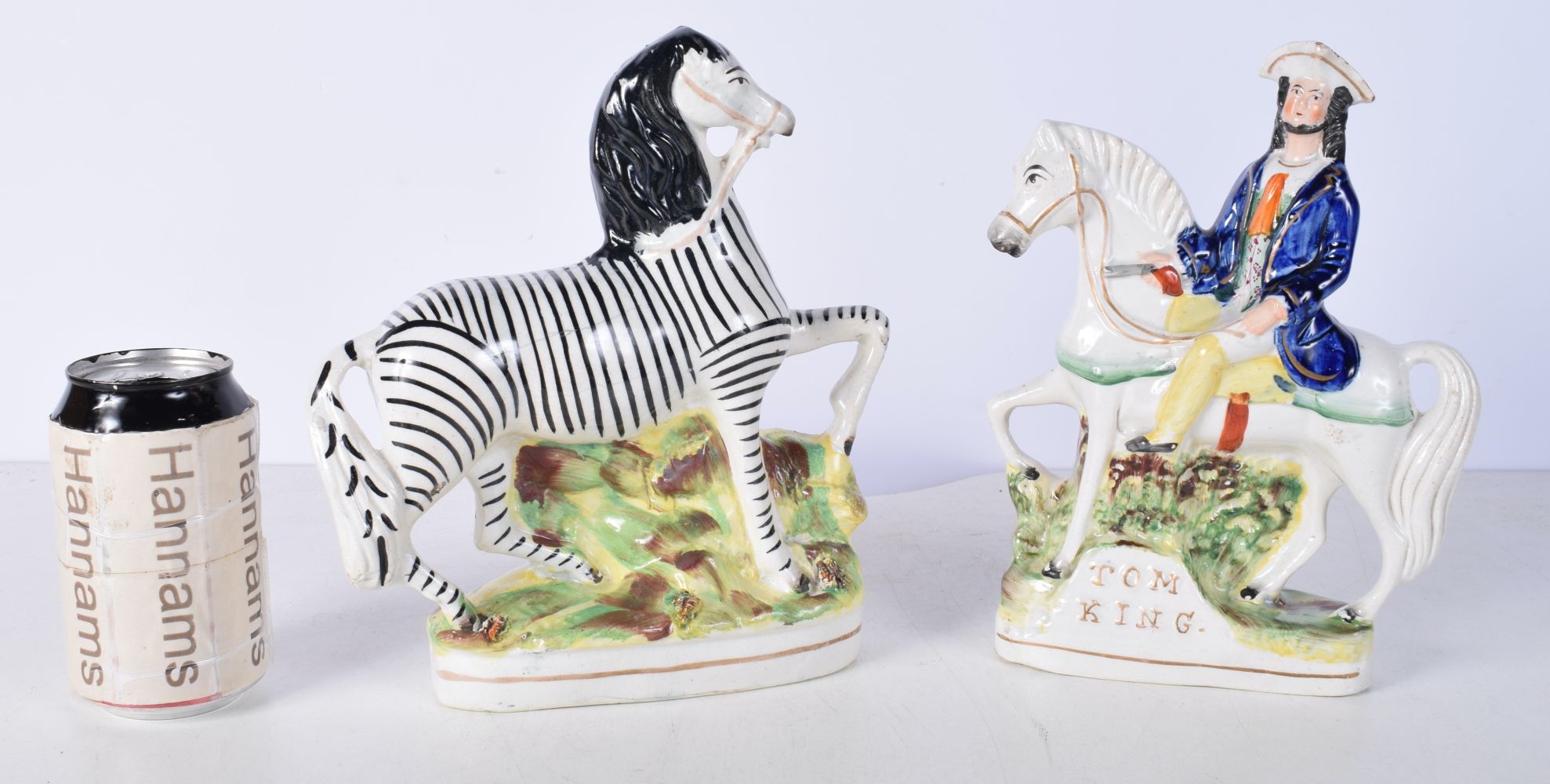 A 19th Century Staffordshire flatback figure of a Zebra together with a Tom King figure 23 cm (2).