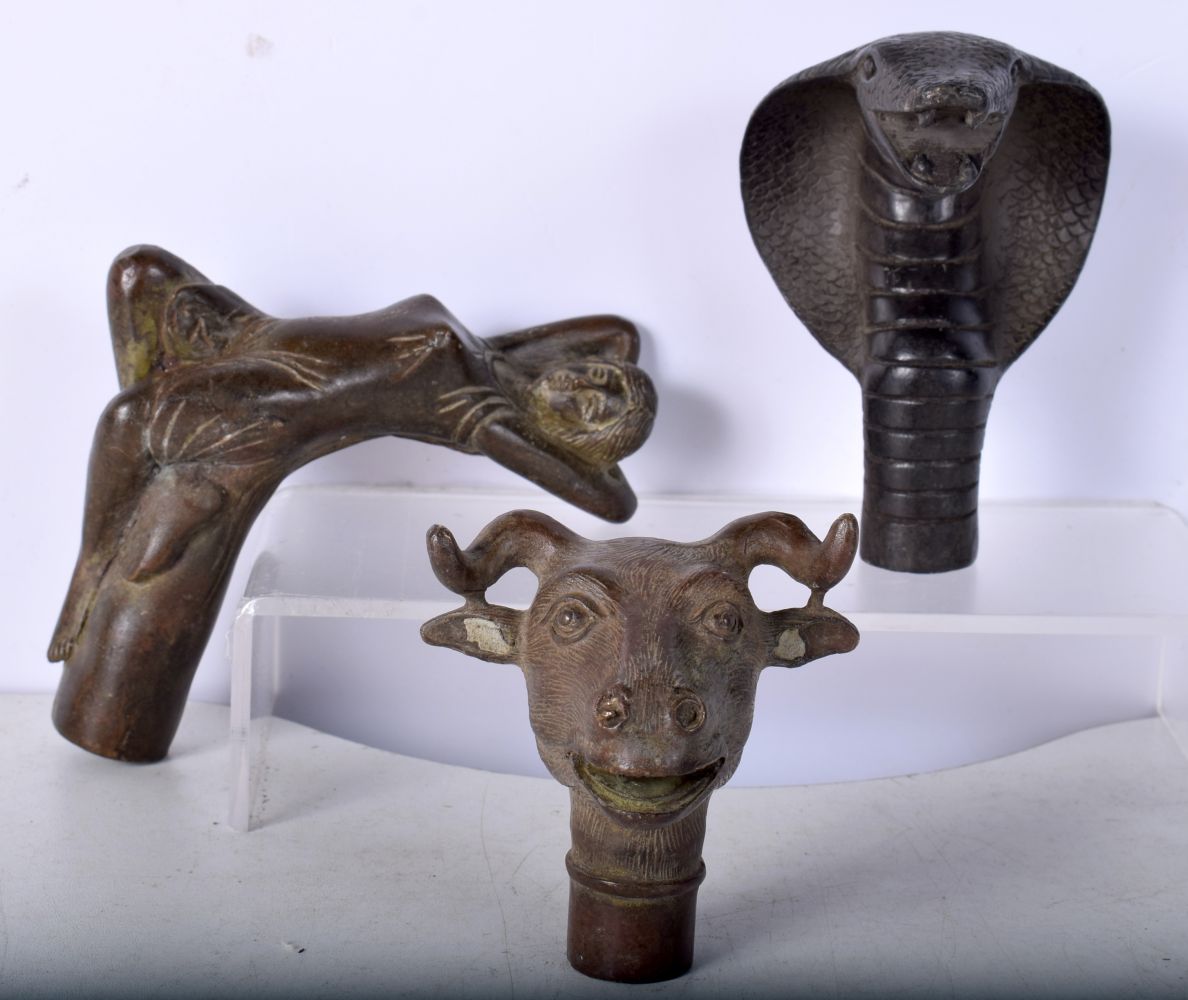 A collection of bronze walking cane handles 11 x 9.5 cm (3),.