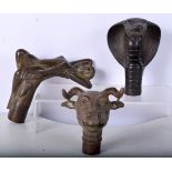 A collection of bronze walking cane handles 11 x 9.5 cm (3),.