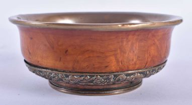 A 19TH CENTURY TIBETAN CARVED WOOD AND COPPER REPOUSSE BOWL decorated with foliage. 12 cm wide.