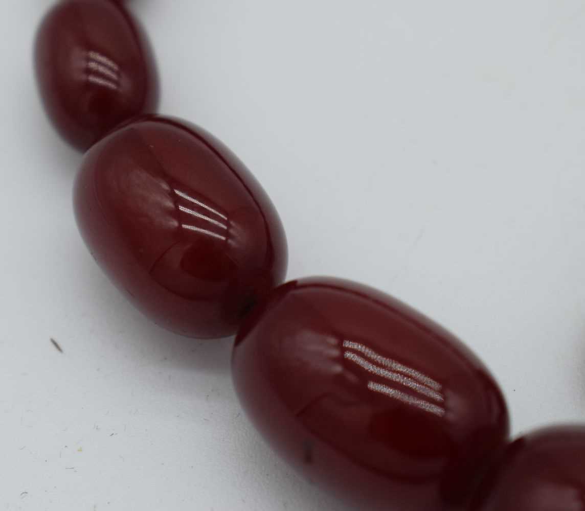 A CHERRY AMBER NECKLACE. 54 grams. 76 cm long, largest bead 2.5 cm x 1.75 cm. - Image 2 of 6