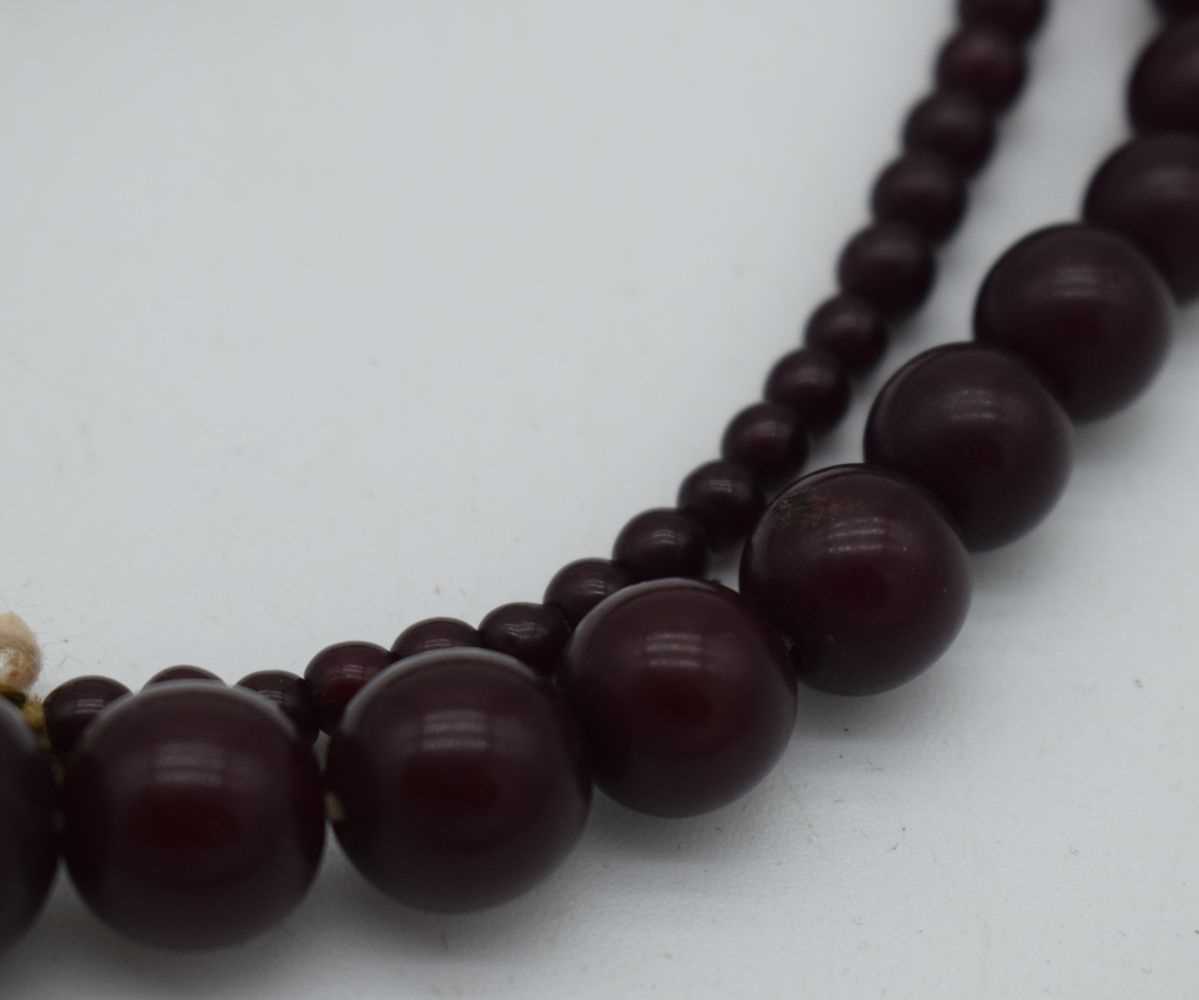 A DEEP RED CHERRY AMBER TYPE NECKLACE. 37 grams. 76 cm long, largest bead 1 cm diameter. - Image 3 of 6