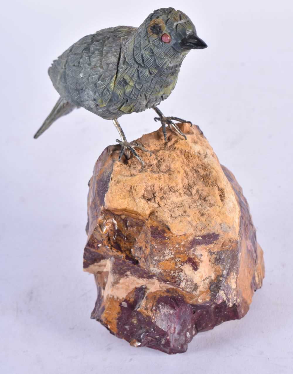 A Carved Hardstone Model of a Bird with Silver Feet Perched on a Rock. 13 cm x 13 cm x 4.5 cm
